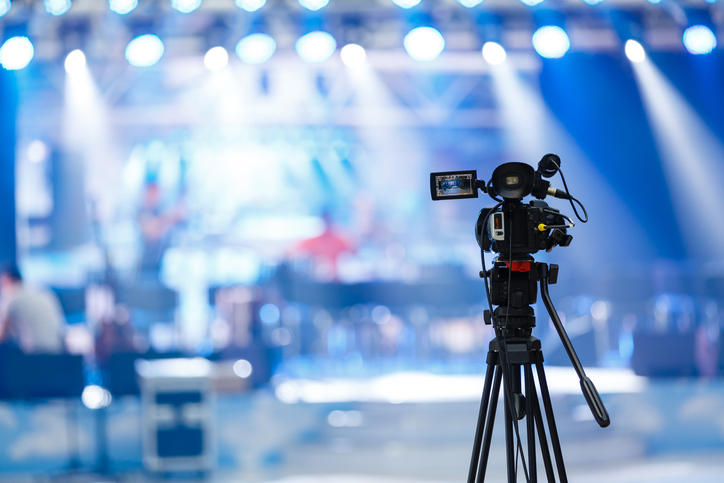 Professional video recording equipment in front of a studio set.